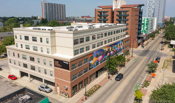 an aerial view of a brick and white building with a colorful mural on the side of it