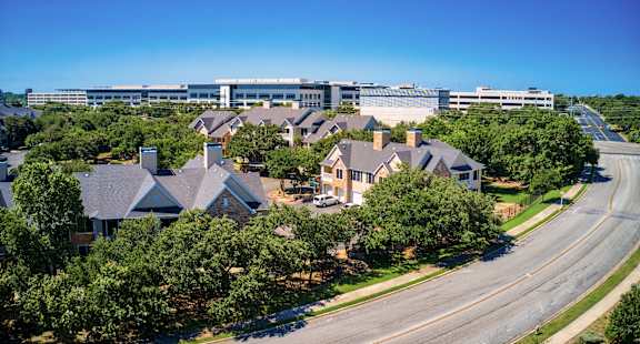 an aerial view of a neighborhood of houses with a city building in the background
