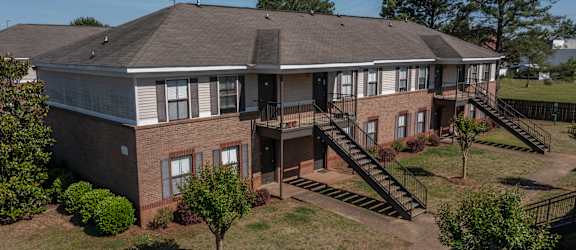 an aerial view of a large brick building with a gray roof
