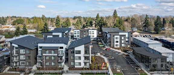 an aerial view of a row of apartment buildings with trees in the background