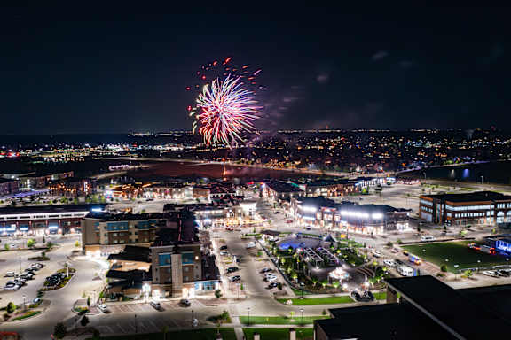 A cityscape at night with fireworks in the sky.