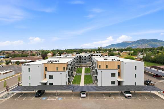 A parking lot in front of a building with a mountain in the background.
