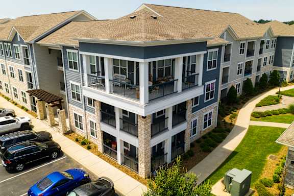 an aerial view of an apartment building with cars parked in a parking lot at Watermark at Steele Crossing, Arkansas