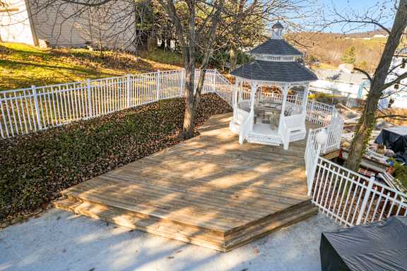 A gazebo sits in the middle of a snowy garden.