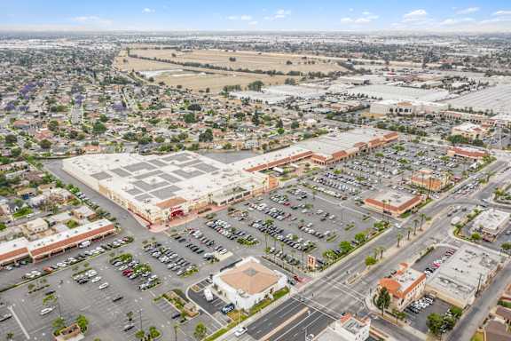 A parking lot is surrounded by buildings and roads.
