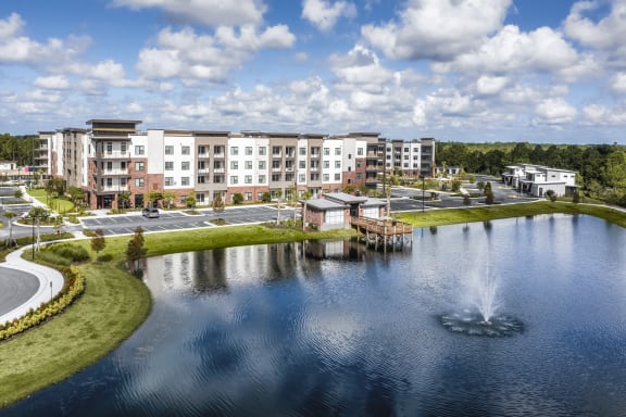 an aerial view of a lake with apartments in the background at The Haven at Lake Britt Apartments, Winter Garden, FL 34787