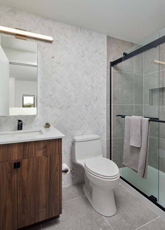 A white toilet sits next to a sink in a bathroom.