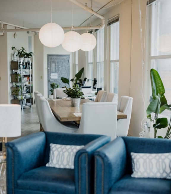 a living room with blue chairs and a dining room table