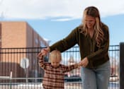 Thumbnail 3 of 7 - A woman and a child are playing on a green artificial grass surface.