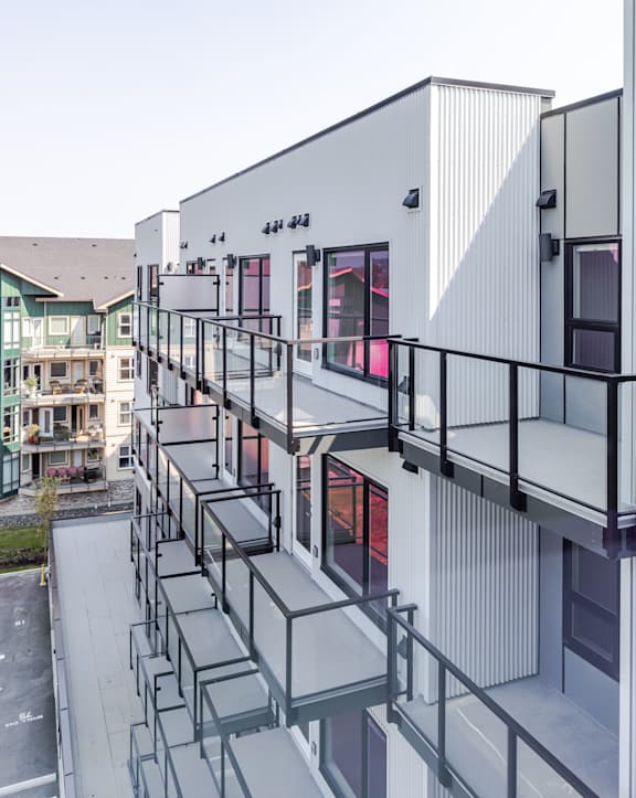 A modern building with a balcony and a glass railing.