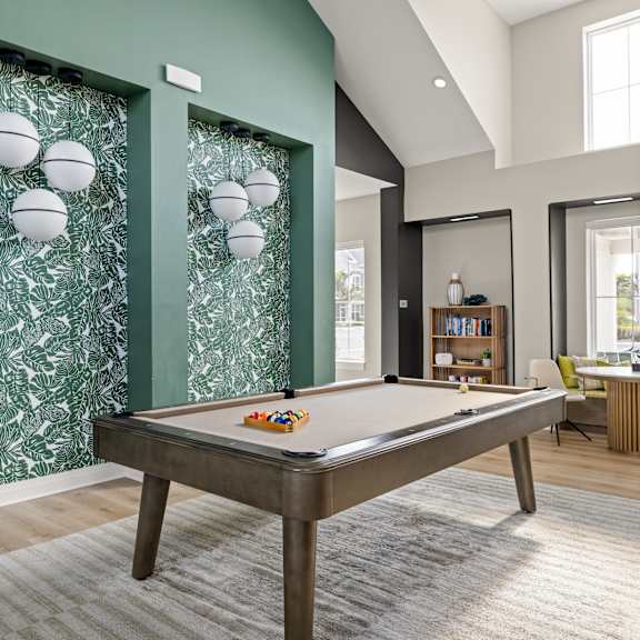 a pool table in a living room with a painting on the wall at Palm Grove, Ellenton, Florida