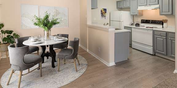A dining room with a white table and grey chairs.