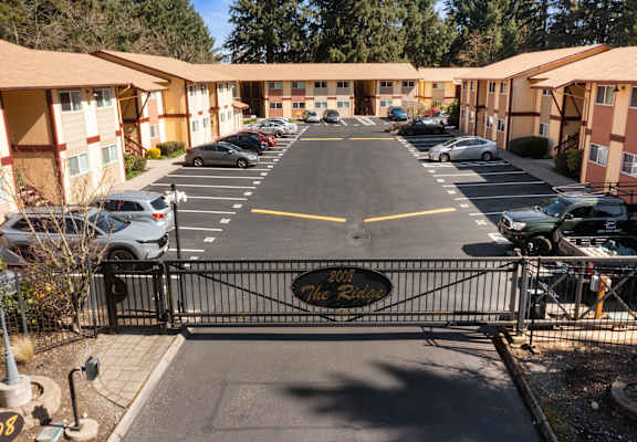 A parking lot in front of a building with a black gate and a sign that says "The Ranch".