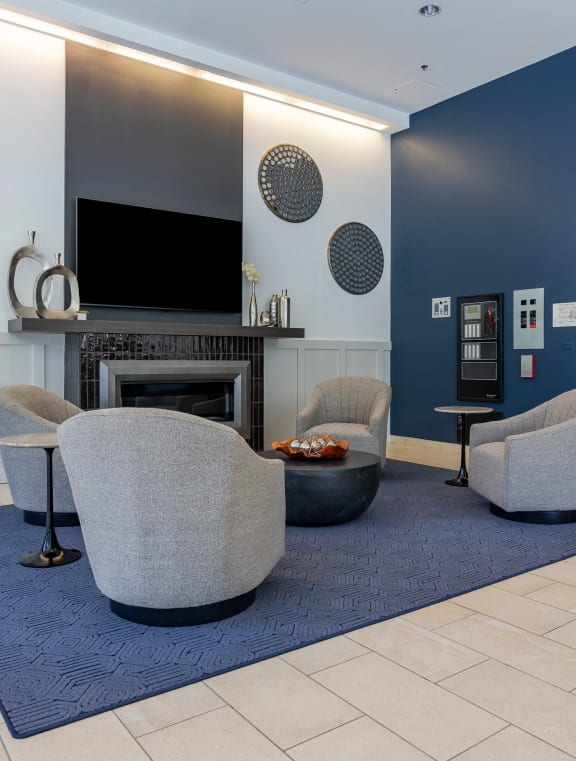 a living room with two chairs and a fireplace     and a television