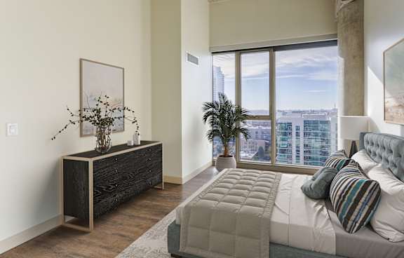 A bedroom with a large bed and a view of the city.