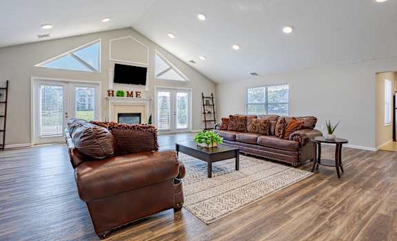 a living room with two leather couches and a fireplace