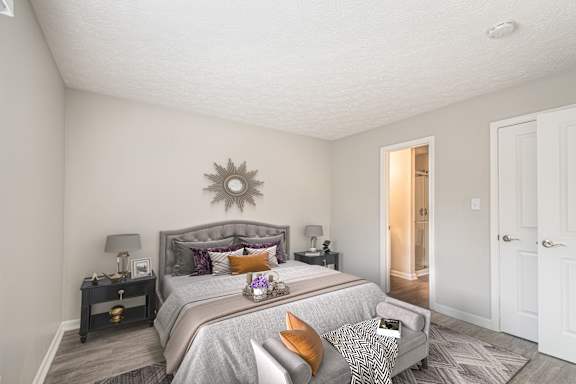 A bedroom with a large bed and a grey headboard.