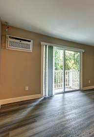 A room with a sliding glass door leading to a balcony.