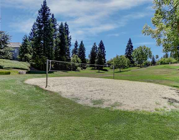A soccer goal is in the middle of a grassy field.