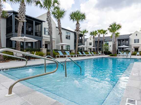 A swimming pool surrounded by palm trees and buildings.