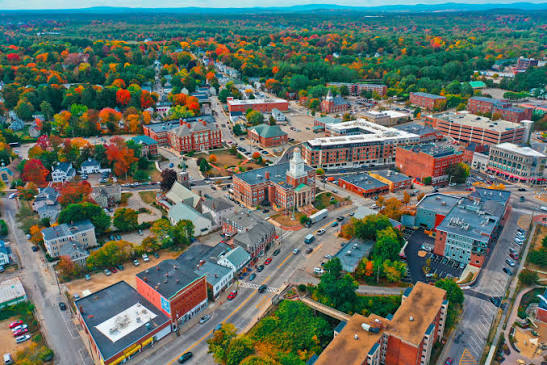 A cityscape with buildings and trees in autumn colors.