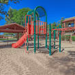 A playground with a blue slide and wooden structure.