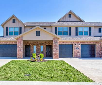 a house with two garage doors and a lawn