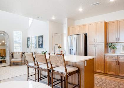 A kitchen with wooden cabinets and a white island.