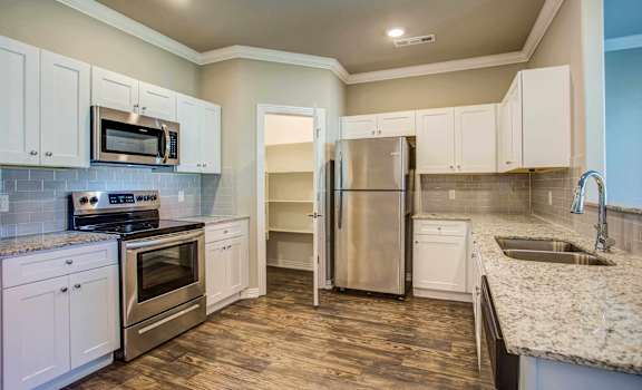 a kitchen with white cabinets and stainless steel appliances