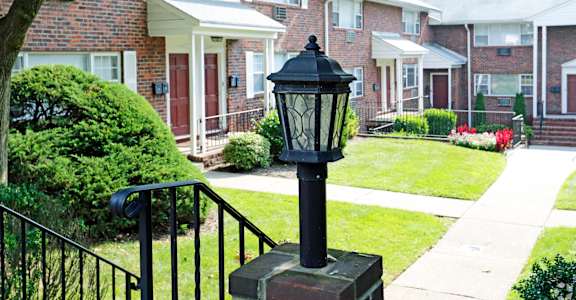 a lamp post in front of a brick building at Willow Gardens Apartments, Teaneck, New Jersey