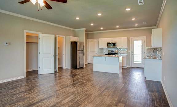 an open kitchen and living room with a ceiling fan