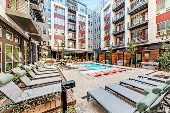 an open courtyard with lounge chairs and a pool in an apartment building at South and Hollis, Charlotte, NC, 28209