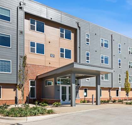 A parking lot in front of a multi-story apartment building.