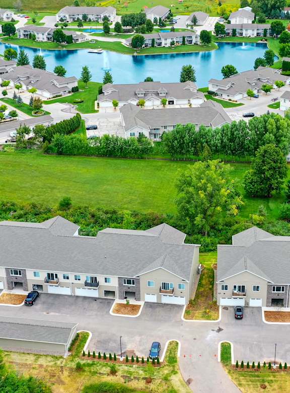 an aerial view of a neighborhood with a lake and houses