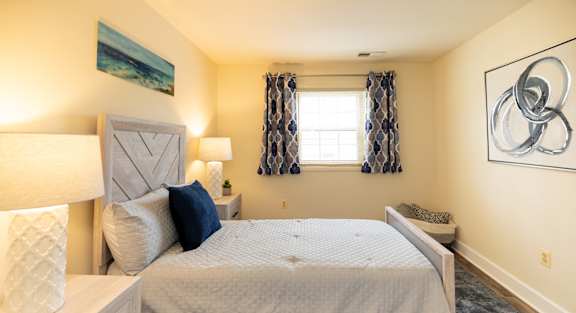 Bedroom with a large bed and a window at Rockdale Gardens Apartments*, Baltimore.