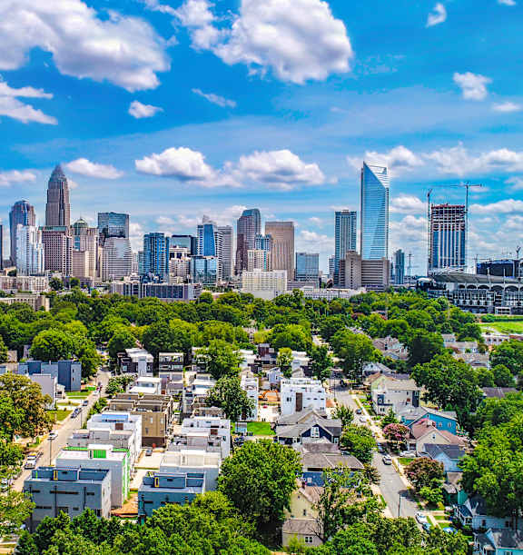 A cityscape with a mix of residential and commercial buildings under a clear sky.