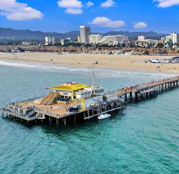 A pier with a yellow crane on it extends into the water.