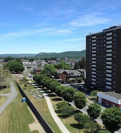 an aerial view of a city with a river in the background and a tall building in the