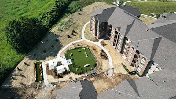 A large building with a green lawn in front.