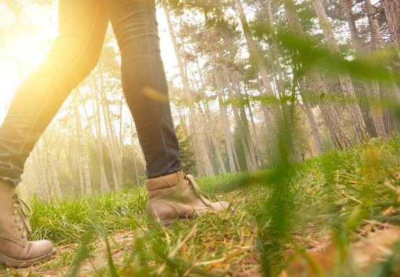 a woman walking through a forest with her boots at The Walker Virginia Center in VA 23059