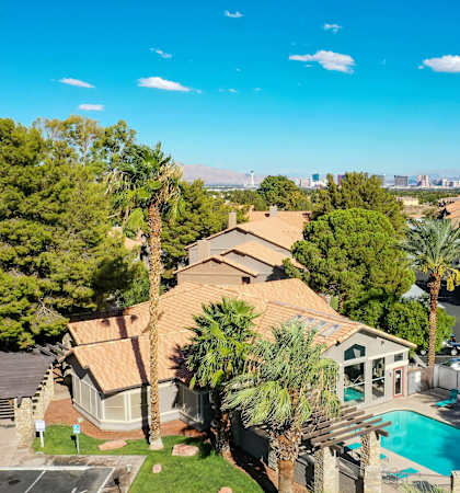 an aerial view of a house with a pool and palm trees