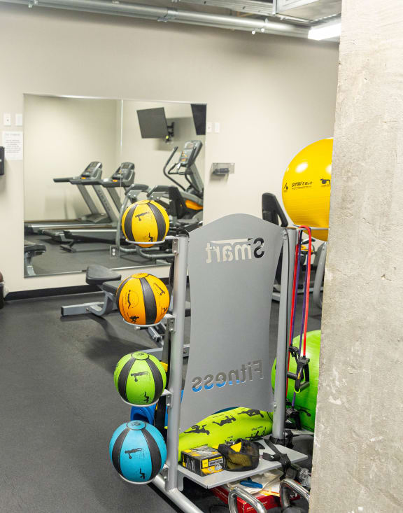 a workout room with weights and mirrors in a gym