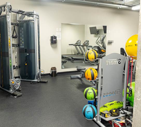 a workout room with weights and mirrors in a gym