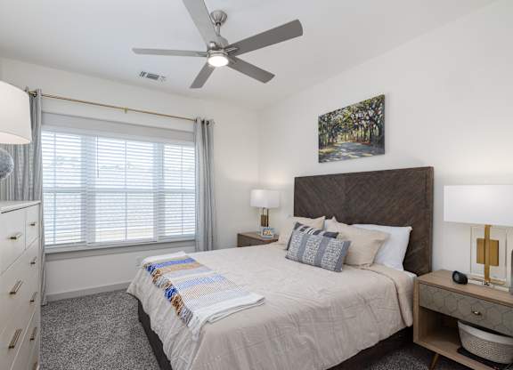 a bedroom with a large bed and a ceiling fan at Allier Port Wentworth Apartments, Port Wentworth, GA