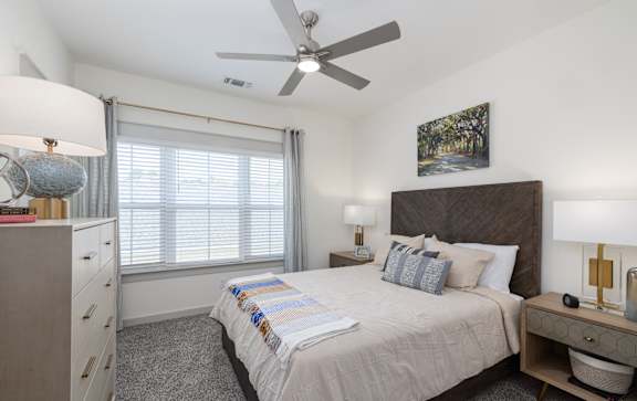 a bedroom with a large bed and a ceiling fan