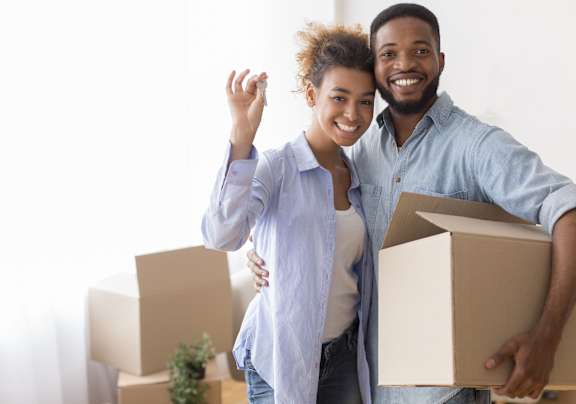 A man and woman are standing in a room with boxes, likely moving into or out of the home  at Conwood Flats Apartment Homes, Memphis, 38107