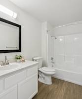 A white bathroom with a sink, toilet, and bathtub.