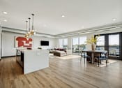 Thumbnail 2 of 4 - A modern kitchen with a white island and wooden floors.