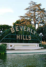 A sign that says Beverly Hills in front of a pond.