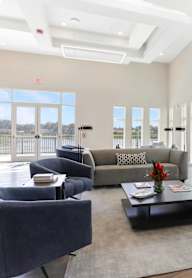 A spacious living room with grey and black furniture.
